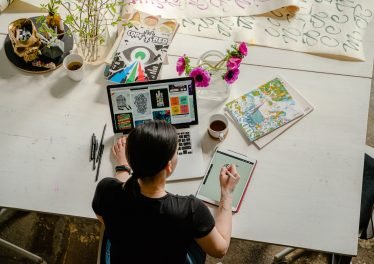 photo of woman writing on tablet computer while using laptop - Где написать Платные отзывы о работе обменника, 2021